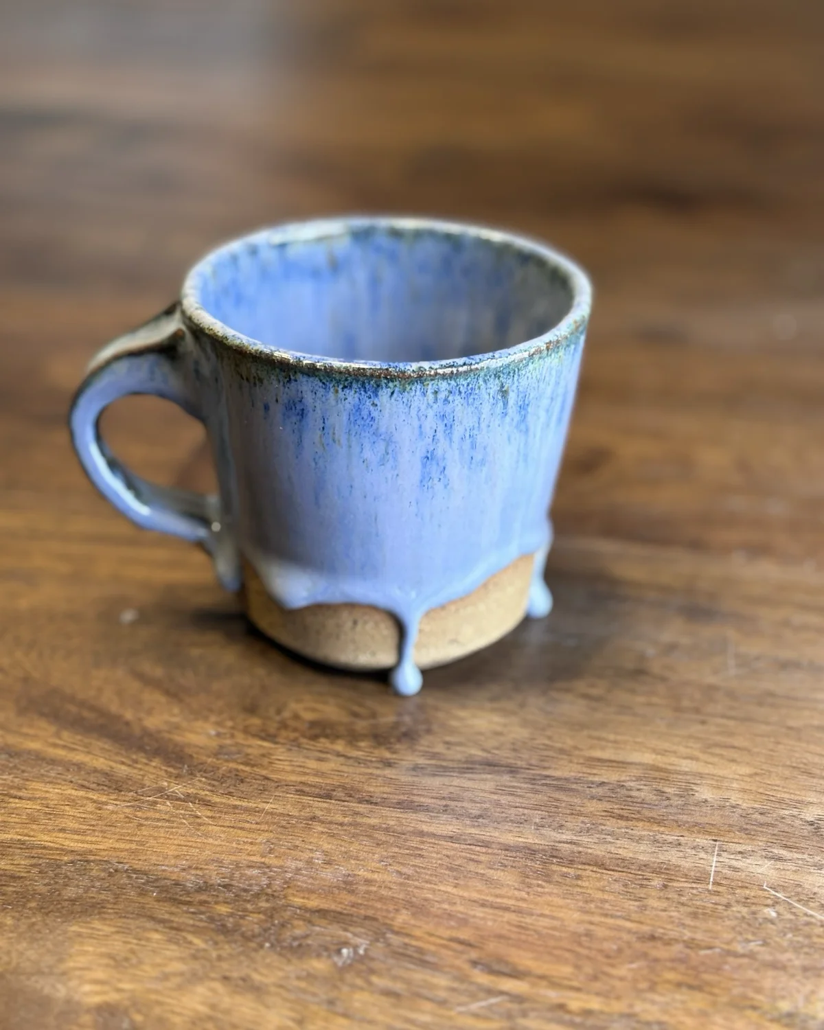 A blue glazed mug with a drip effect