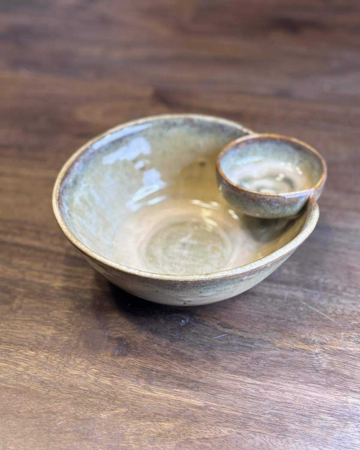 A stoneware serving bowl in a moss glaze